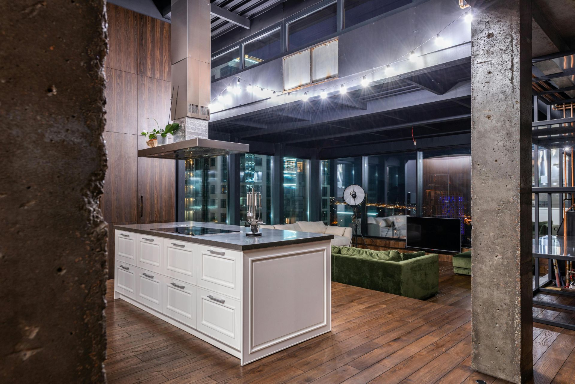 Spacious contemporary loft apartment featuring sleek kitchen and cityscape view.